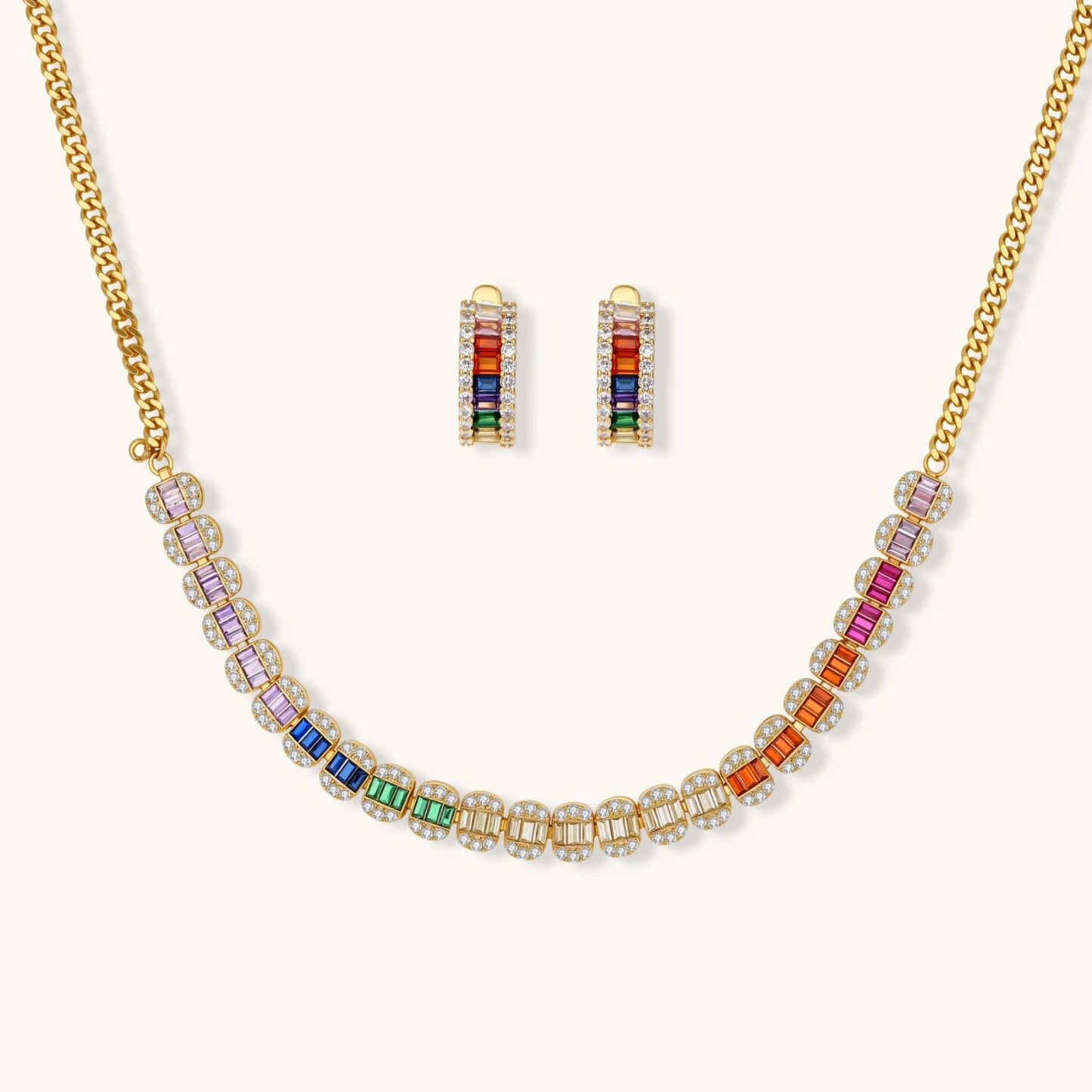 Gold-plated jewelry set featuring rainbow baguette-cut cubic zirconia stones in geometric design on cream background