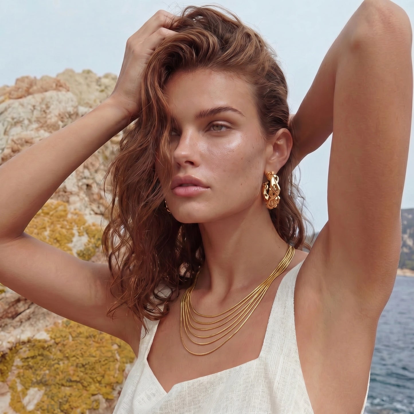Woman with gold jewelry against a natural background