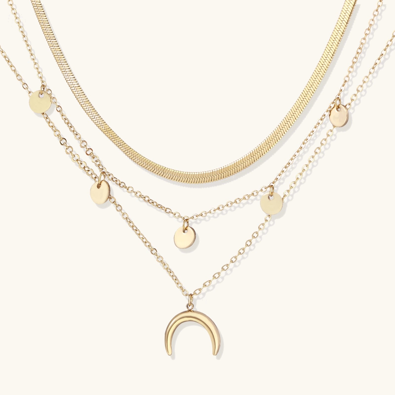 Three gold necklaces with various pendants on a white background