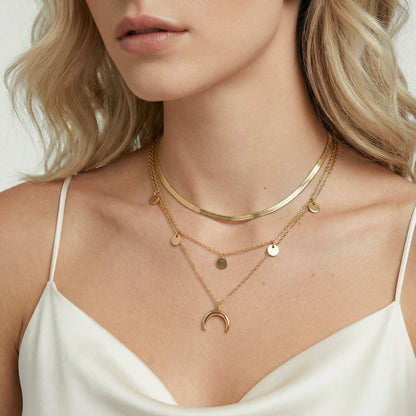 Close-up of a woman wearing gold necklaces with a plain background